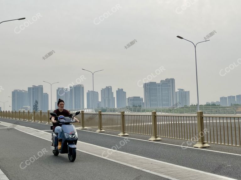 骑电动车者通过运河上的桥梁